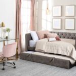4 Benefits of Color-Coding Your Home Decor A room with an office desk and a day bed near the window. The furniture has a soft tone color of pink, white, tan, and gray.