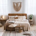 4 Tips for Adding a Rustic Touch to Your Home The interior of a rustic bedroom with wood floors and decorations plus a bed with a comforter and several pillows.