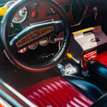 Unique Upgrades To Personalize Your Vehicle's Interior Interior view of a vehicle's front seat. The vehicle has red leather seats, a black steering wheel, and a cooler in passenger's seat.