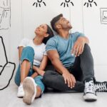 Things in Your Home You Didn’t Know Were Customizable A young couple sitting on the floor with sketches of possible home customizations around them thinking about improvements.