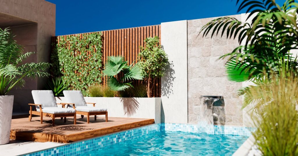 A modern outdoor pool with turquoise-colored water, two lounge chairs on a wooden deck, and green plants nearby.