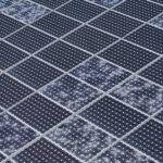 An aerial view of a large solar panel. Several individual cells on the panel are cracked from hail damage.