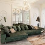 5 Tips for Choosing the Right Mirror for Your Space A green couch faces forward with a mirror behind it, set against white walls and gray parquet flooring with a brown rug.