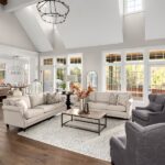 Tips for Choosing the Right Furniture for Your Living Room An opulent-looking living room showcasing two couches and two chairs in front of large windows and next to a fireplace.